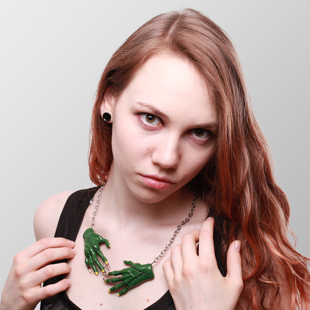 Kette Zombie Hands Dark mit zwei dunkelgrünen Zombiehänden die sich in der Mitte treffen