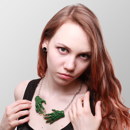 Kette Zombie Hands Dark mit zwei dunkelgrünen Zombiehänden die sich in der Mitte treffen