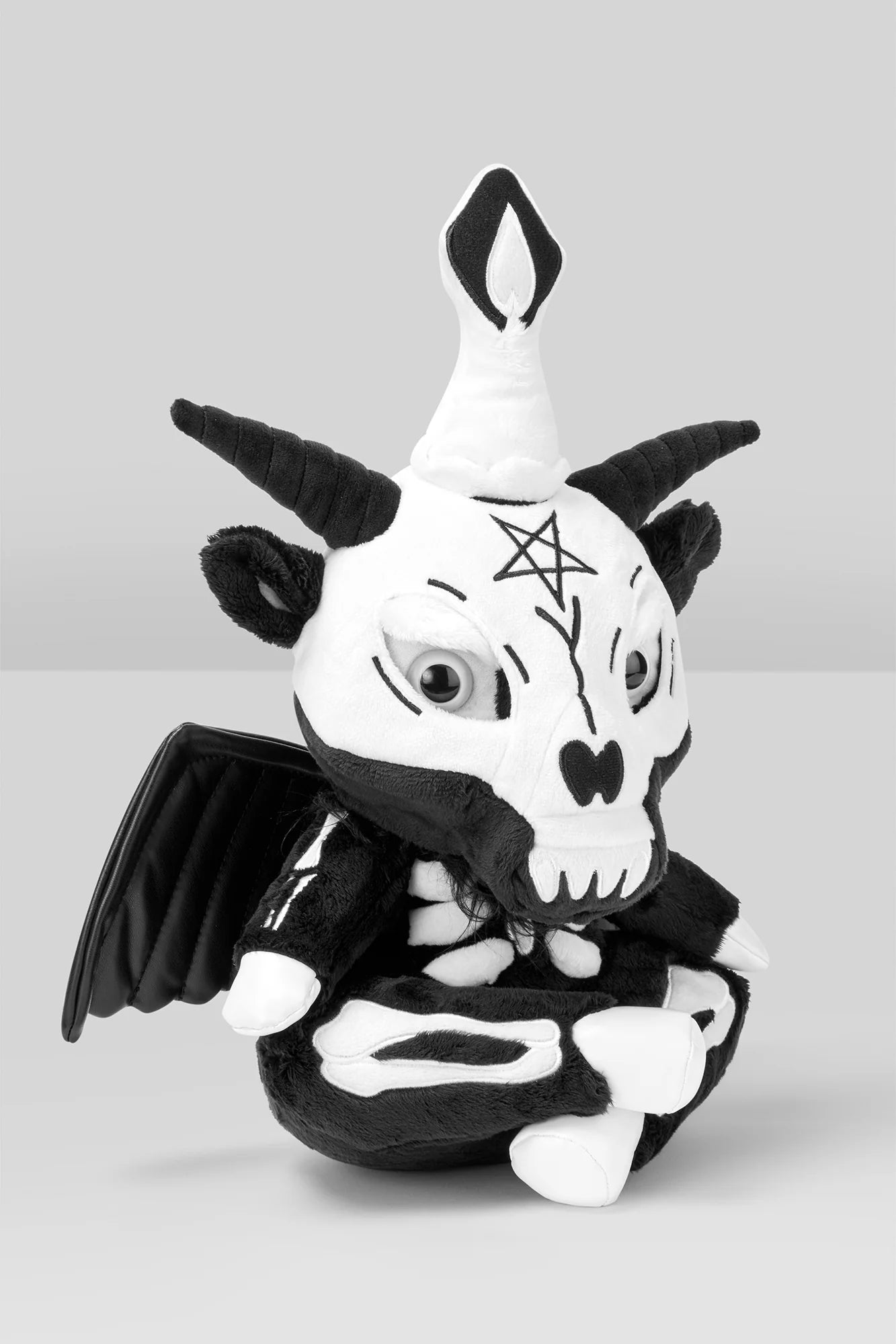 Schwarz-weißes Baphomet-Kuscheltier im Schneidersitz in Skelettoptik mit Pentagram auf Stirn