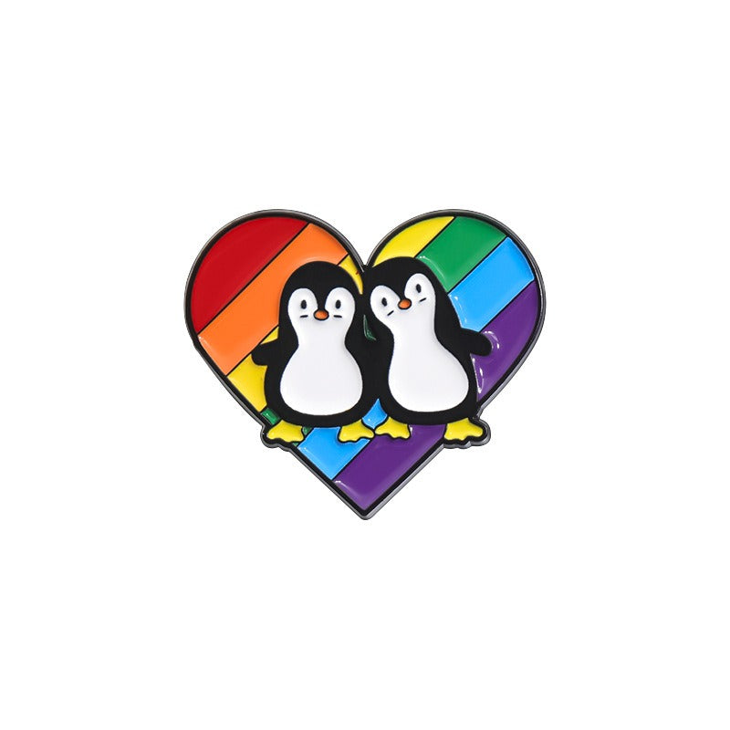 Kleiner, herzförmiger Emaille-Anstecker PRIDE PENGUIN ENAMEL PIN im Regenbogendesign mit zwei Pinguinen von Moon Attic