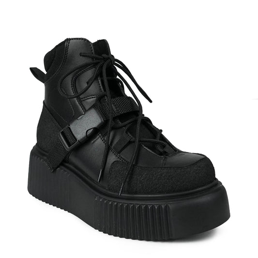 Knöchelhoher schwarzer Schuh aus Kunstleder und Stoffeinsätzen mit Plateausohle und Zierschnalle