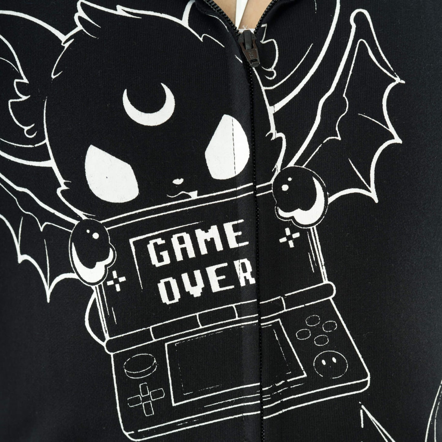 Nahaufnahme schwarz-weiße Sweatshirtjacke GAME OVER HOOD im Comicdesign mit vielen Details und Fledermausohren auf Kapuze von Heartless