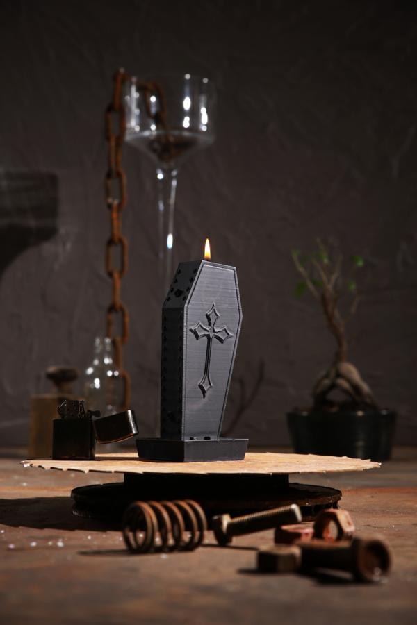 Schwarze, sargförmige Kerze mit Kreuzaufdruck