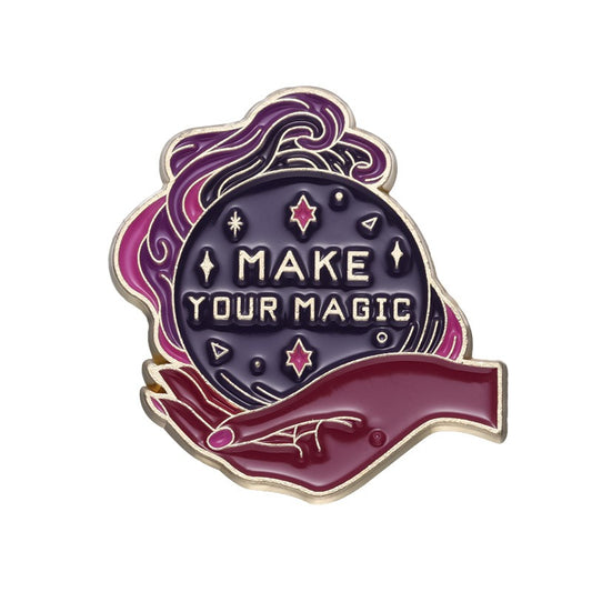 Pink- und lilafarbender Emaille-Pin mit Zauberkugel in Hand mit Aufschrift 'Make Your Magic'